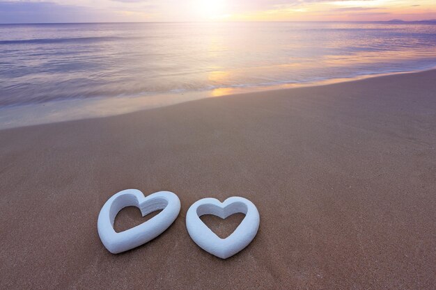 Foto hartvorm op het zand op het strand tegen de lucht