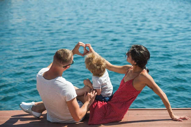 Hartvorm van handen door gelukkige familie op zomervakantie. hart van liefde op zee