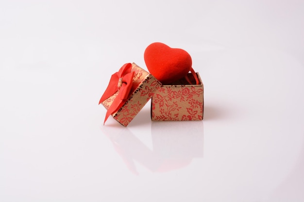 hartvormig object en een geschenkdoos met een rood lint op witte achtergrond