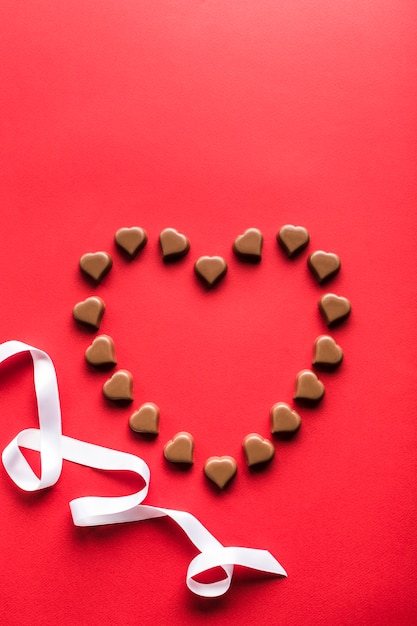 Hartvormige chocolade op rode achtergrond voor Valentijnsdag