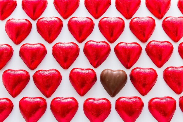 Hartvormige chocoladesuikergoed verpakt in rode folie voor Valentijnsdag.