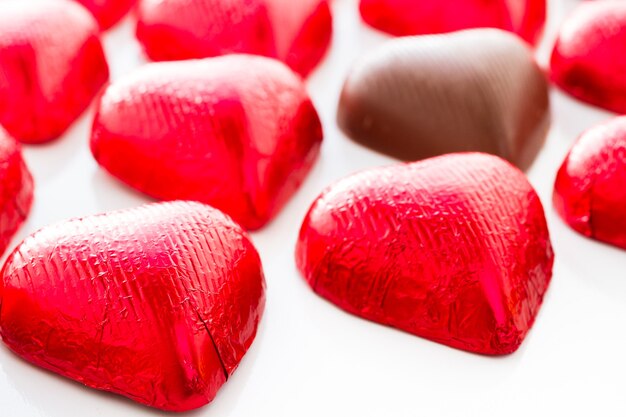 Hartvormige chocoladesuikergoed verpakt in rode folie voor Valentijnsdag.