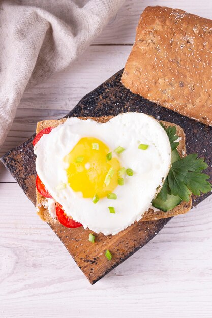 Hartvormige eiersandwich op houten plank