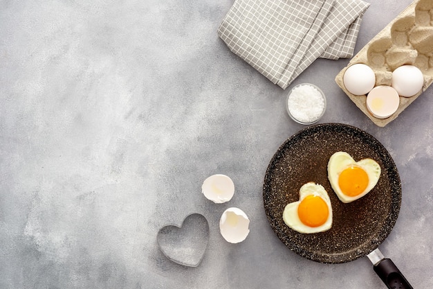 Hartvormige gebakken eieren koken in een pan