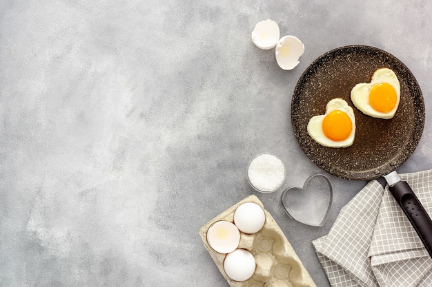 Hartvormige gebakken eieren koken in een pan