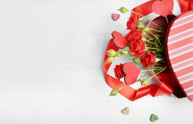 Hartvormige geschenkdoos met bloemen op houten tafel