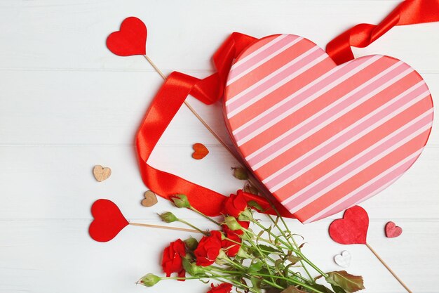 Hartvormige geschenkdoos met bloemen op houten tafel