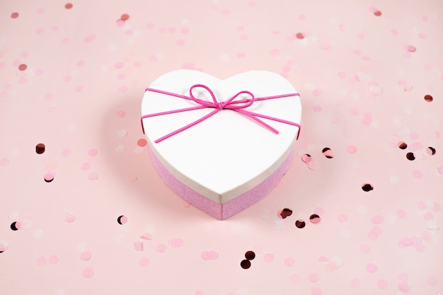 Hartvormige geschenkdoos met roze strik en confetti, bovenaanzicht