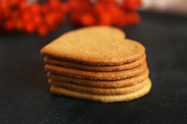 Hartvormige koekjes en asbessen op donkergrijze achtergrond