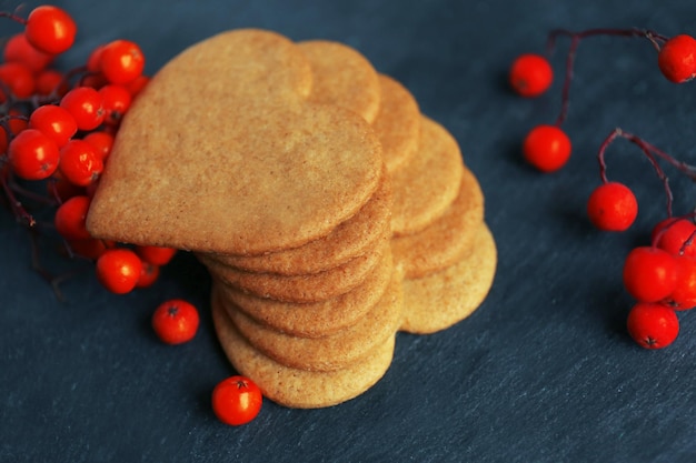 Hartvormige koekjes en asbessen op donkergrijze achtergrond