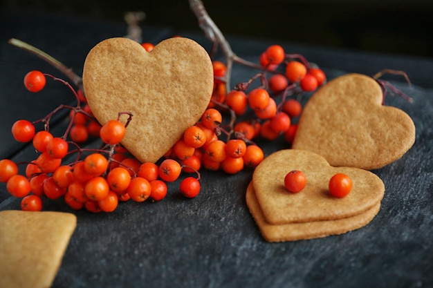 Hartvormige koekjes en asbessen op donkergrijze achtergrond