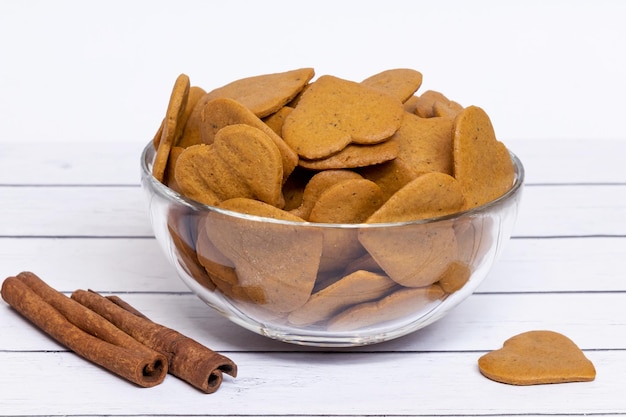 Hartvormige koekjes in een glazen vaas voor Valentijnsdag op een lichte houten achtergrond