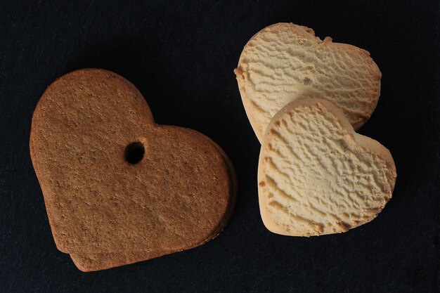 hartvormige koekjes op een zwarte achtergrond - bovenaanzicht