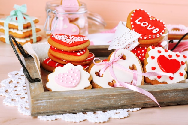 Hartvormige koekjes voor Valentijnsdag op dienblad, op een houten achtergrond kleur