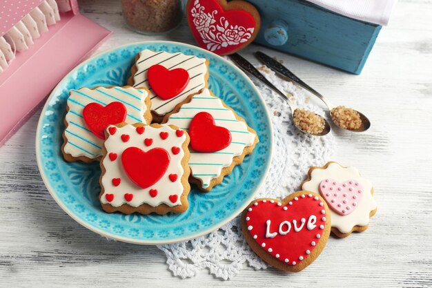 Hartvormige koekjes voor Valentijnsdag op plaat, op een houten achtergrond kleur