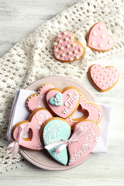 Hartvormige koekjes voor Valentijnsdag op plaat, op een houten achtergrond kleur