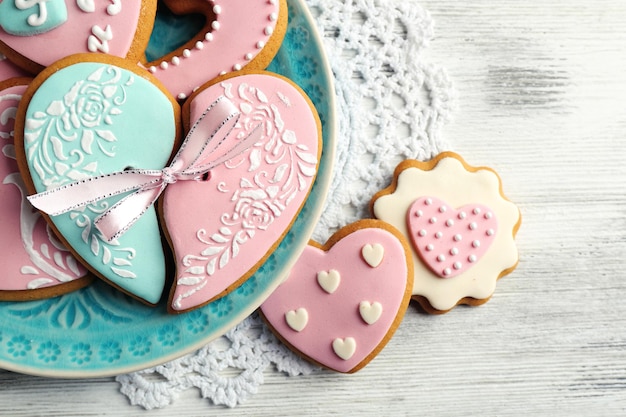 Hartvormige koekjes voor Valentijnsdag op plaat, op een houten achtergrond kleur