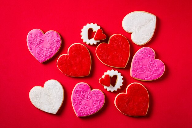 Hartvormige koekjes voor Valentijnsdag op rode achtergrond