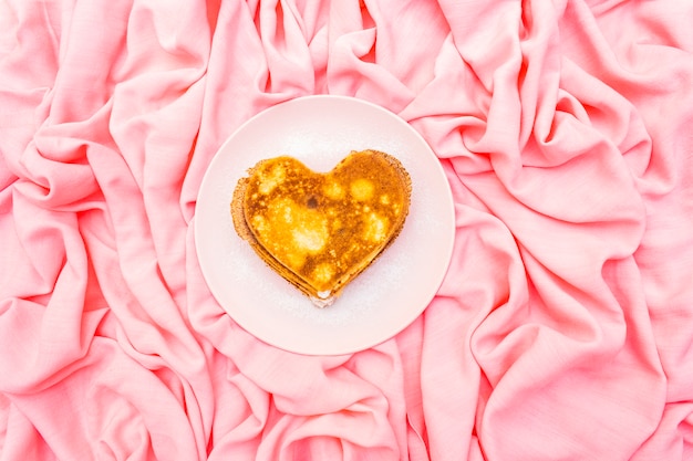 Hartvormige pannenkoeken voor romantisch ontbijt op roze plaat