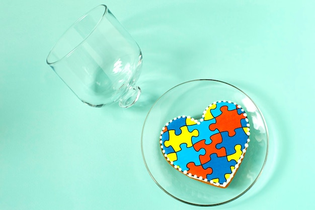 Hartvormige peperkoek met patroon van puzzels en glazen deksel Concept van autisme