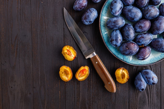 Photo harvest fresh ripe plum in a saucepan on the table. cooking organic dessert