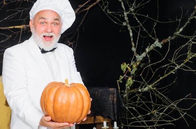 Harvest pumpkin bearded cook in chef hat with pumpkin farm market autumn vegetables diet food