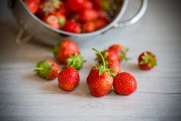 harvest of red ripe natural strawberries on a wooden table