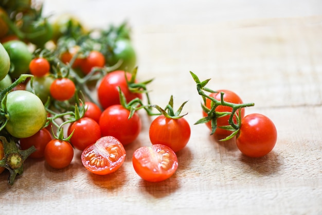 Harvesting fresh tomato organic with green and ripe red tomatoes on wood 