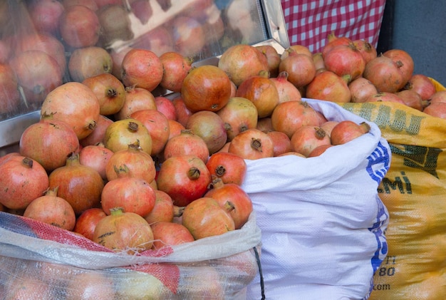 Foto raccolta dei melograni in sacchi compro melograni rossi al mercato contadino locale