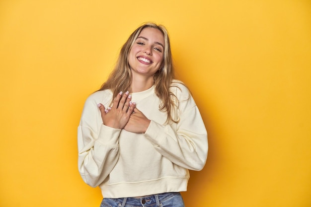 Photo has friendly expression pressing palm to chest love concept