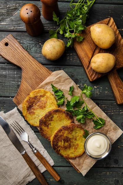 Hash browns food and potato cakes vegetable fritters with\
ketchup on white wooden board