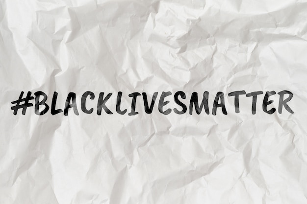 Hashtag black lives matter on wrinkled paper