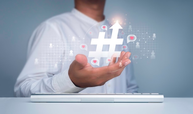 Concetto di hashtag. icona hashtag con freccia in alto nella mano dell'uomo e simbolo di persone con cuore, amore nei fumetti che galleggiano sul web del social network. marketing di post e media tag alla moda e virale.