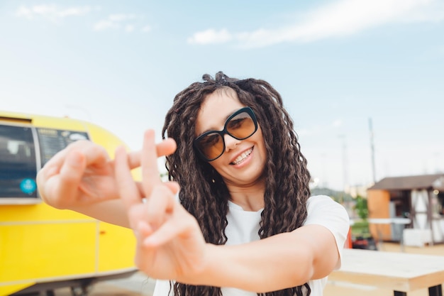 The hashtag of the gesture symbol Hands show gesture is viral web social networks network a young woman with dreadlocks shows a hashtag gesture on the street