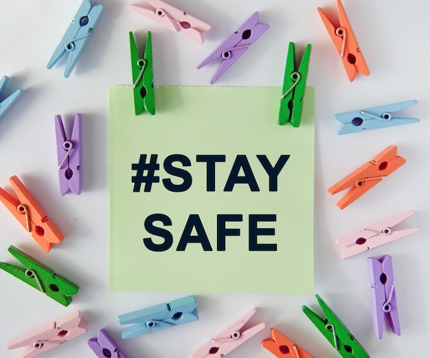 Hashtag staysafe - text on notes sheet and colorful clothespins