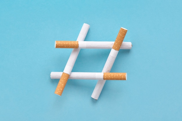 Hashtag-teken gemaakt van sigaretten op blauw, pictogram voor niet roken of geen tabaksdag.