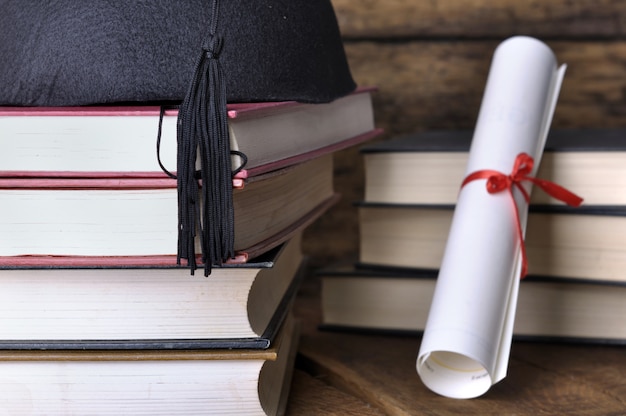 Hat and dilpoma with piled books