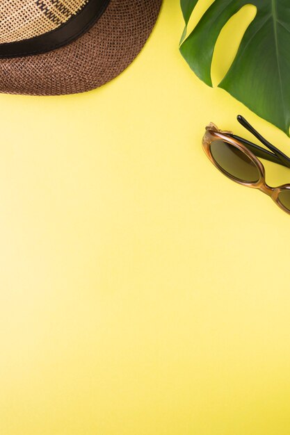 Hat leaf monstera sunglasses on yellow background copy space