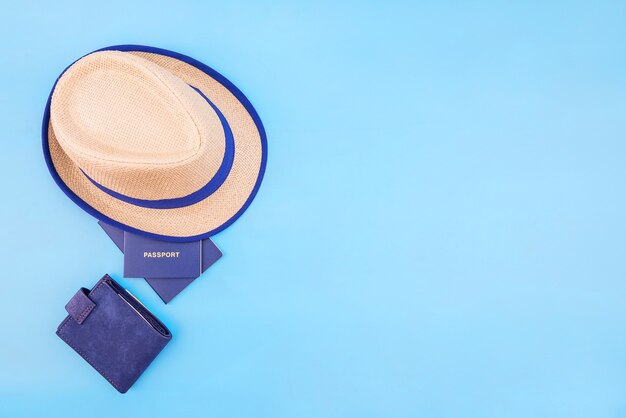 Hat, passports and wallet on blue with copy space