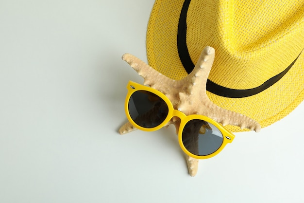 Hat, seastar, and sunglasses on white background