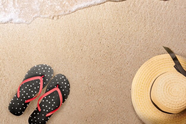 Hat and slipper on the sandy beach