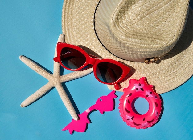 Шляпа и солнцезащитные очки на синем фоне с морской звездой и сгенерированной морской звездой.