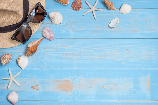 hat, , sunglasses,  and shell on blue 