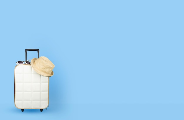 hat and sunglasses on suitcase against blue background