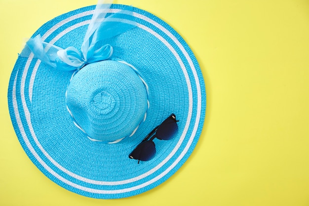 Hat and sunglasses on yellow background