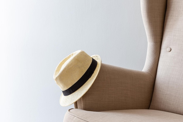 Hat with the brim lies on the handle of the arm chair