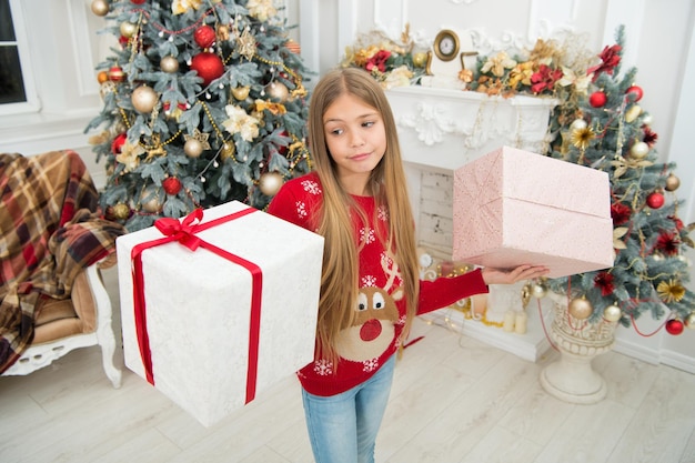 홀리즐리 크리스마스 보내세요. 아이는 휴가를 즐긴다. 크리스마스 트리와 선물입니다. 새해 복 많이 받으세요. 겨울. 크리스마스 온라인 쇼핑. 가족 휴가. 크리스마스 전날 아침. 슬픈 어린 소녀.