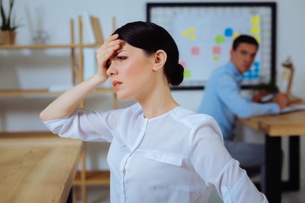 have a problem. sick girl standing in semi position and putting right hand on the forehead while looking forward