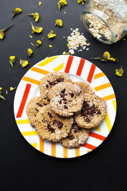 Havermeelkoekjes met chocolade op kleurrijke plaat