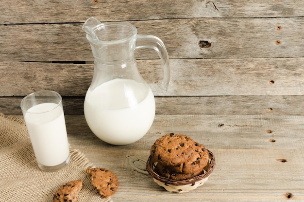 Havermout chocoladeschilferkoekjes kruik en glas melk rustieke houten achtergrond Land diner